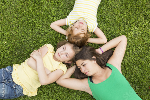 Drei Mädchen liegen im Gras und erholen sich