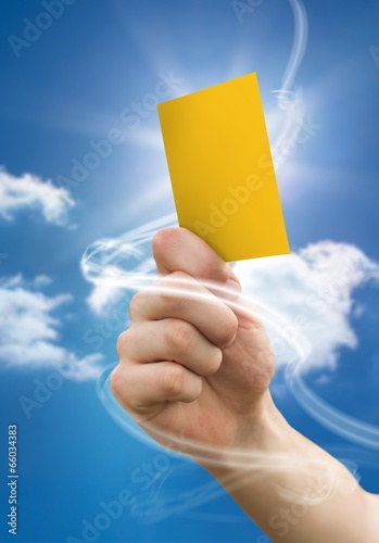 Composite image of hand holding up yellow card