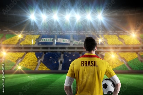 Composite image of brasil football player holding ball photo
