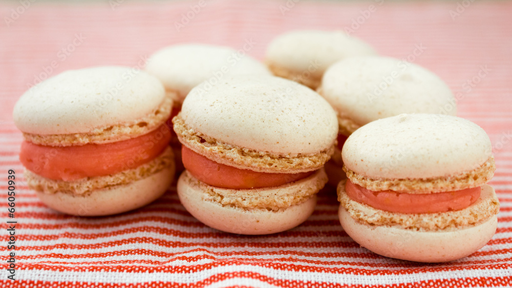 macaroons close up with orange cream and pink background