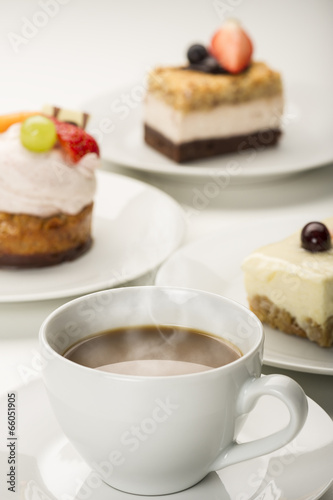 Hot fresh cup of coffee with a variety of cakes