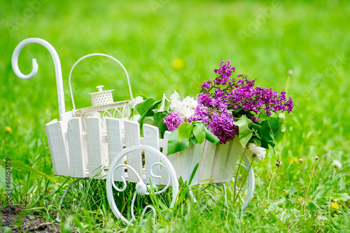 Decorative white cart with beautiful lilac flowers