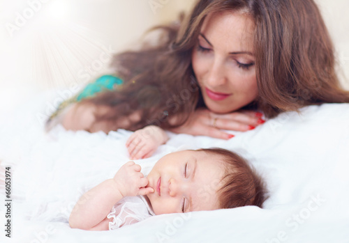beautiful mother watching newborn daughter sleeps