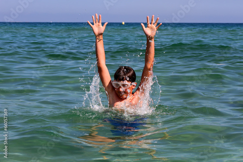 Active boy playing with sea water.