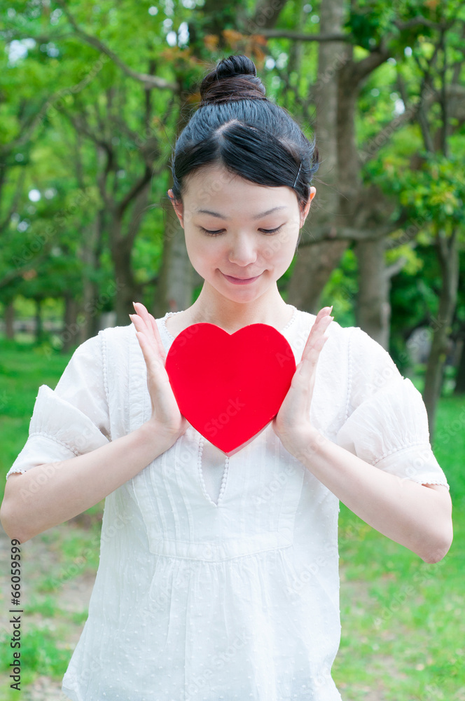 緑を背景にして微笑む女性