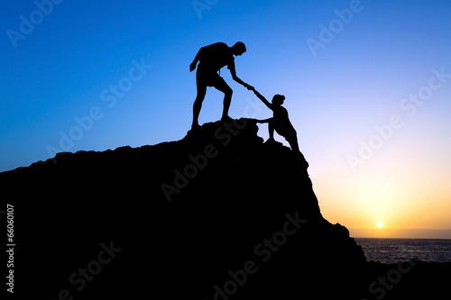 Man and woman couple help silhouette in mountains #66060107