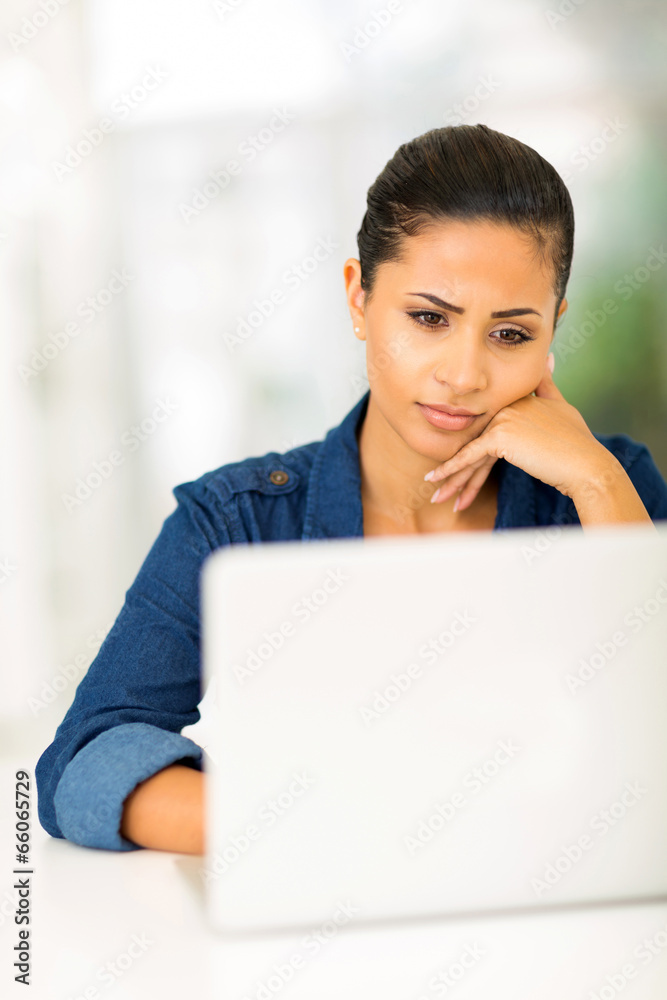 worried young woman looking at computer screen worried young woman looking at computer screen