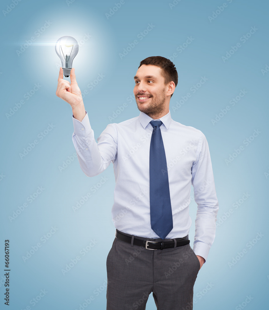 handsome businessman holding light bulb handsome businessman holding light bulb
