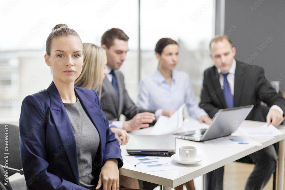businesswoman in office with team on the back