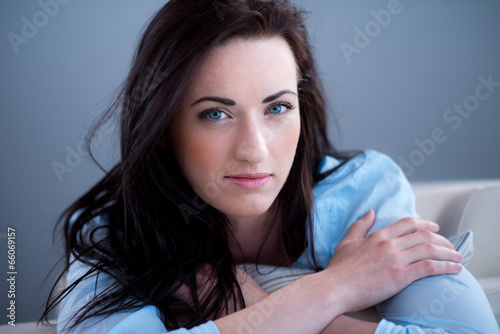 Fotografía cheerful young brunette lying on her sofa relaxed at home