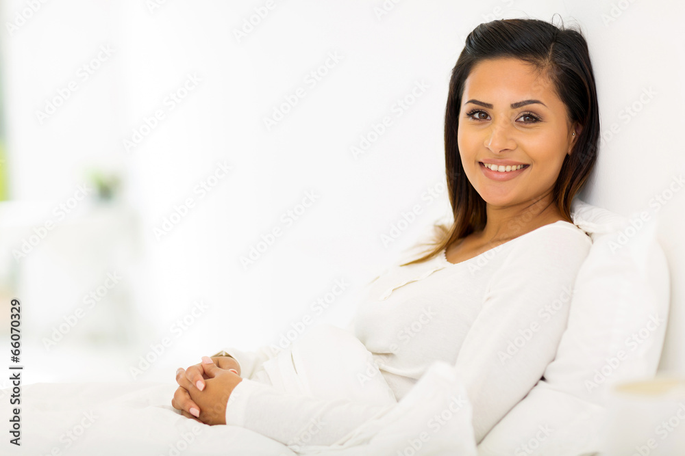 young woman in pajamas sitting on bed young woman in pajamas sitting on bed