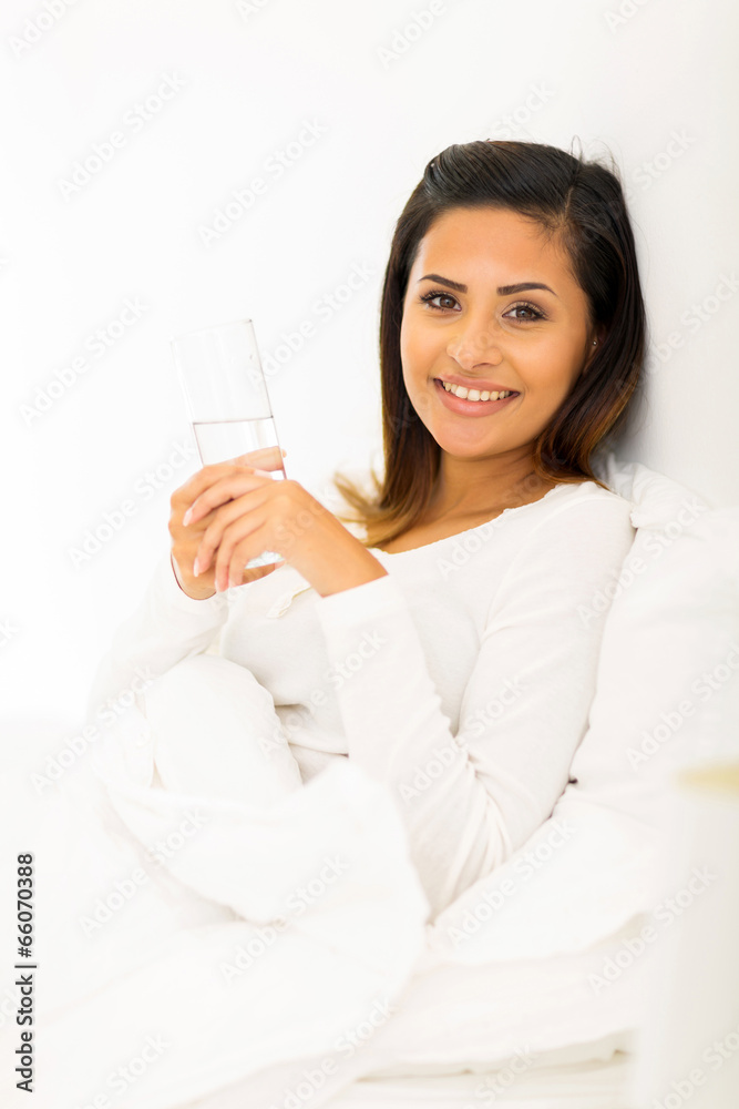 cheerful woman holding a glass of water in bed cheerful woman holding a glass of water in bed