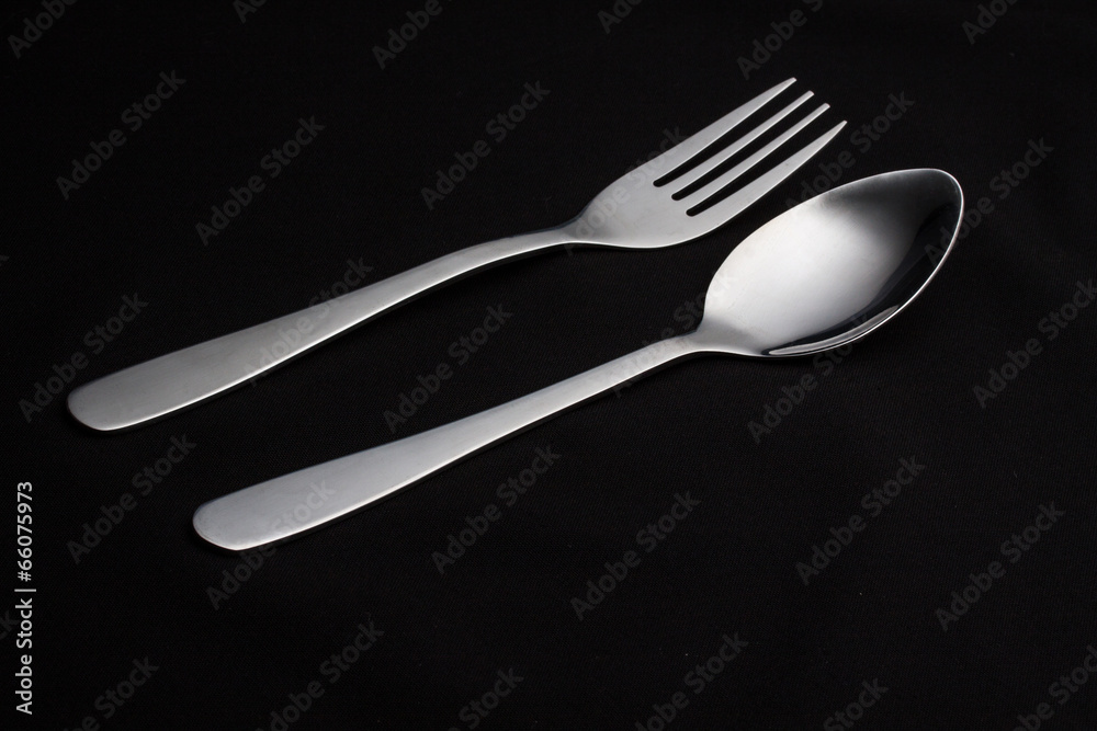 a silver fork with spoon isolated on black background a silver fork with spoon isolated on black background