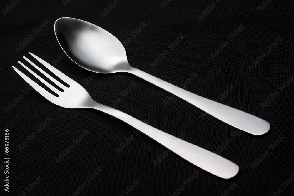 a silver fork with spoon isolated on black background a silver fork with spoon isolated on black background
