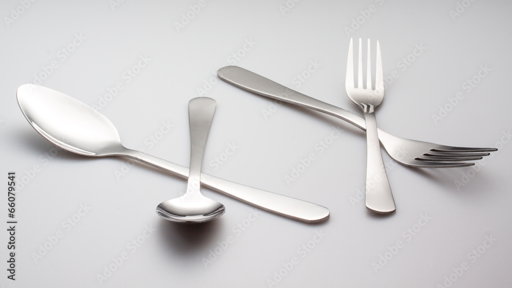 a silver fork with spoon isolated on gray background a silver fork with spoon isolated on gray background