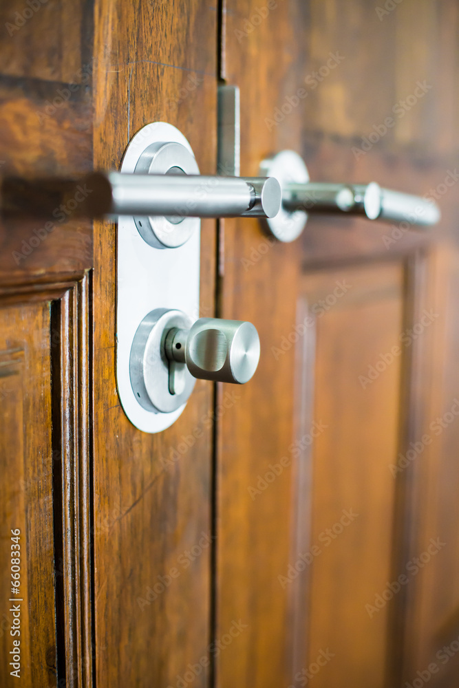 modern chrome door handle on a wooden door modern chrome door handle on a wooden door