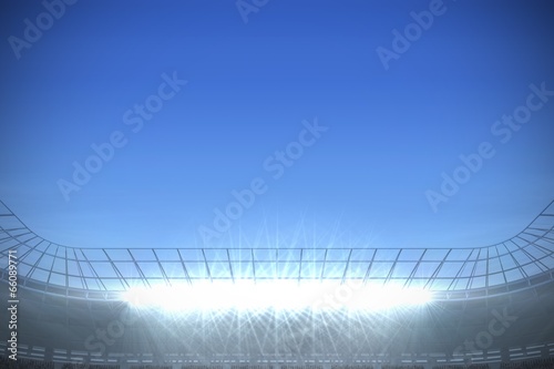 Large football stadium with spotlights under bright blue