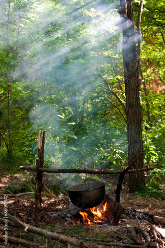 Dinner cooks in a large pot over an open fire