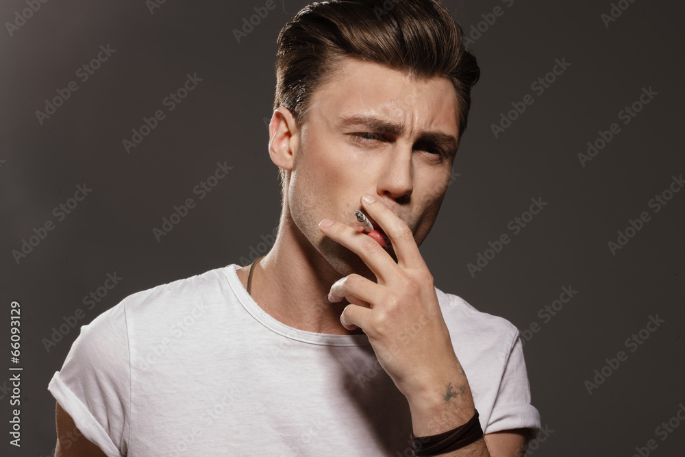 Handsome young man smoking cigarette Handsome young man smoking cigarette