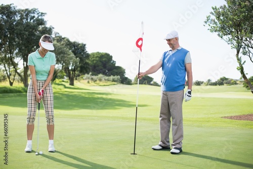 Golfing couple at the eighteenth hole on the golf course