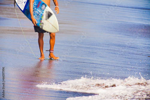 Surfer walking on coast in Bali