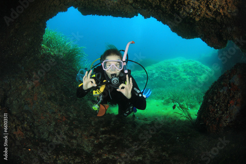 Young woman scuba diving in underwater cave