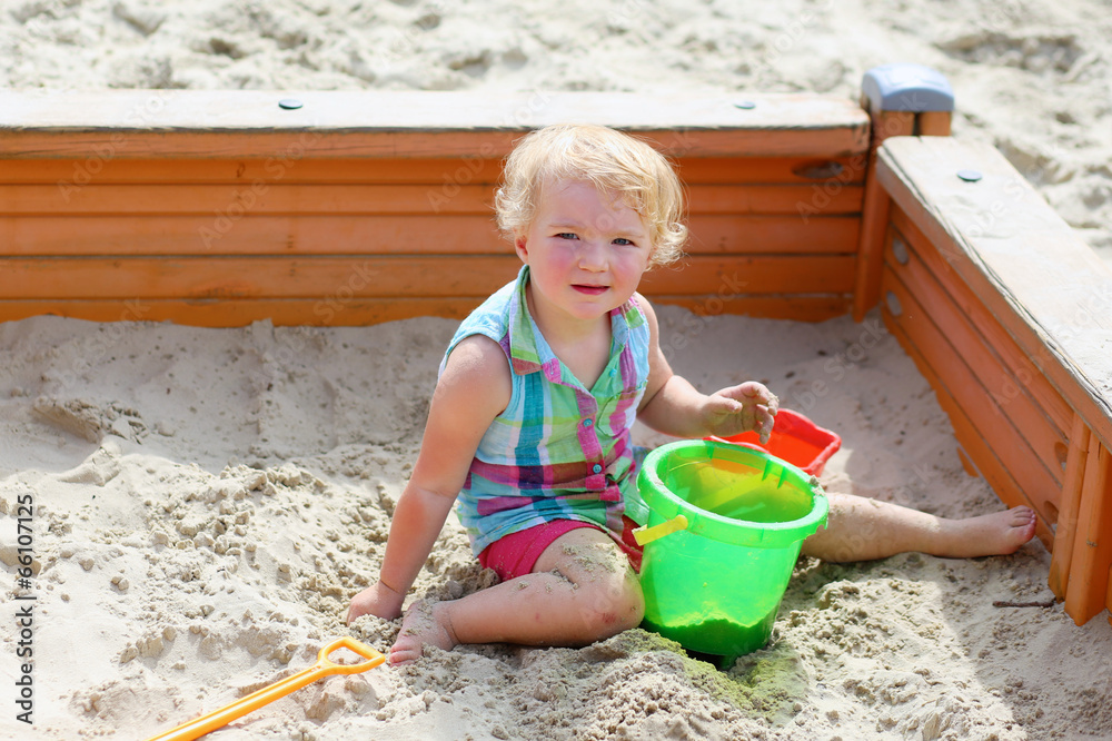 Little toddler girl playing with toys in sandbox Little toddler girl playing with toys in sandbox