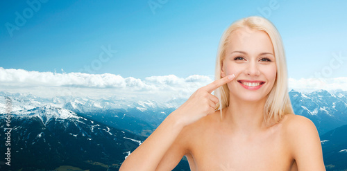smiling young woman pointing to her nose