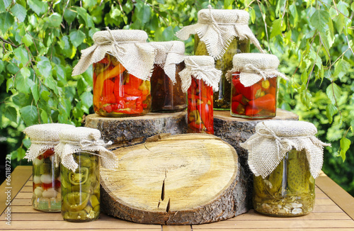 Jars of preserves on wooden table in the garden