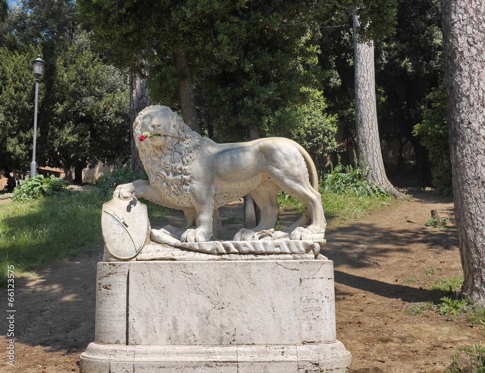Lion de pierre, une rose rouge entre les dents