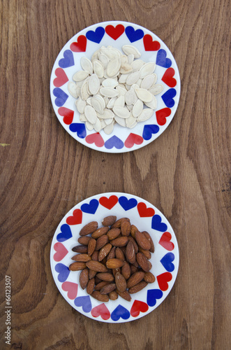 almond and pumpkin seed in ceramic plate with hearts photo