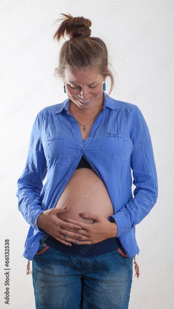 Pregnant woman with naked belly hugs herself and smiling Pregnant woman with naked belly hugs herself and smiling