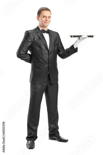 Full length portrait of a happy waiter holding a tray