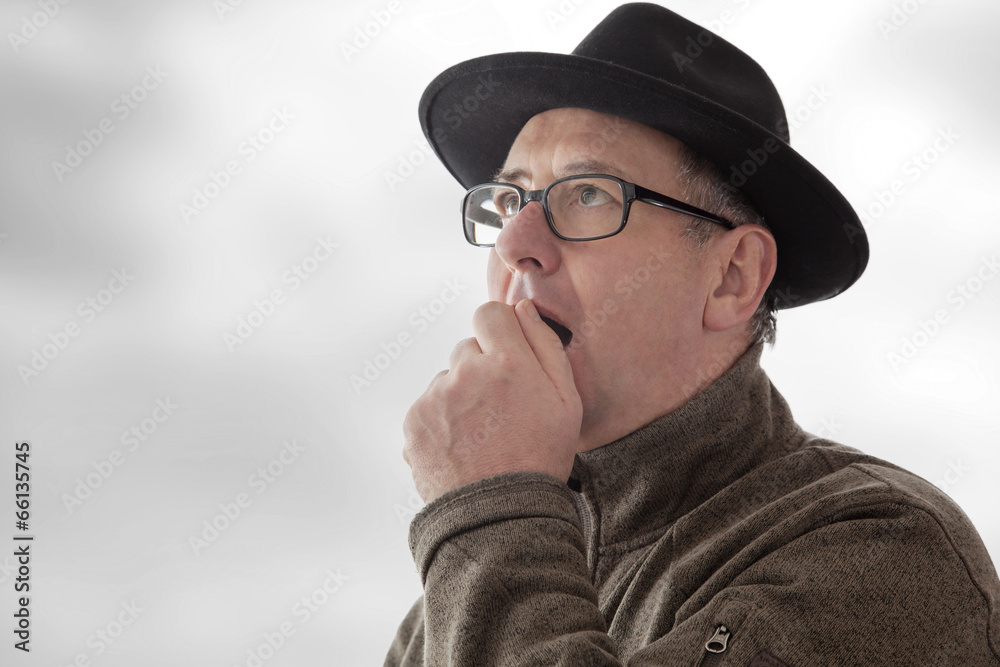 Serious man with hat and anxious glance