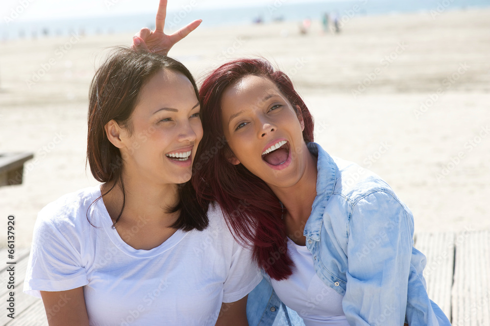 Cheerful sisters having fun at the beach