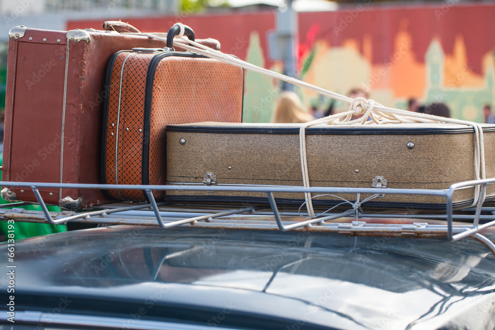 old suitcases on a luggage carrier on the roof of an ancient car Stock