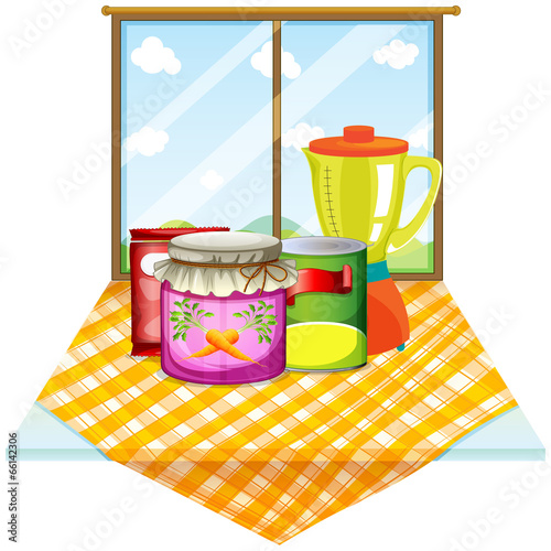 A table near the window with foods inside the containers