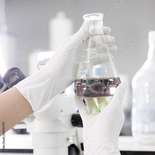a chemist holding a tube with liquid