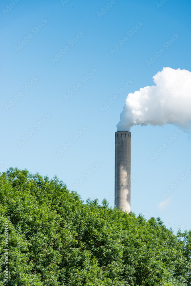 Smoking chimney against a bright blue sky Smoking chimney against a bright blue sky