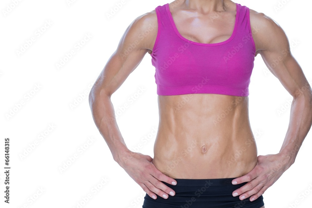 Female bodybuilder posing with hands on hips mid section Female bodybuilder posing with hands on hips mid section