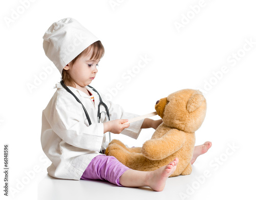 Adorable child dressed as doctor playing with toy over white
