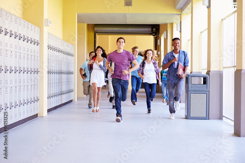 Group Of High School Students Running In Corridor