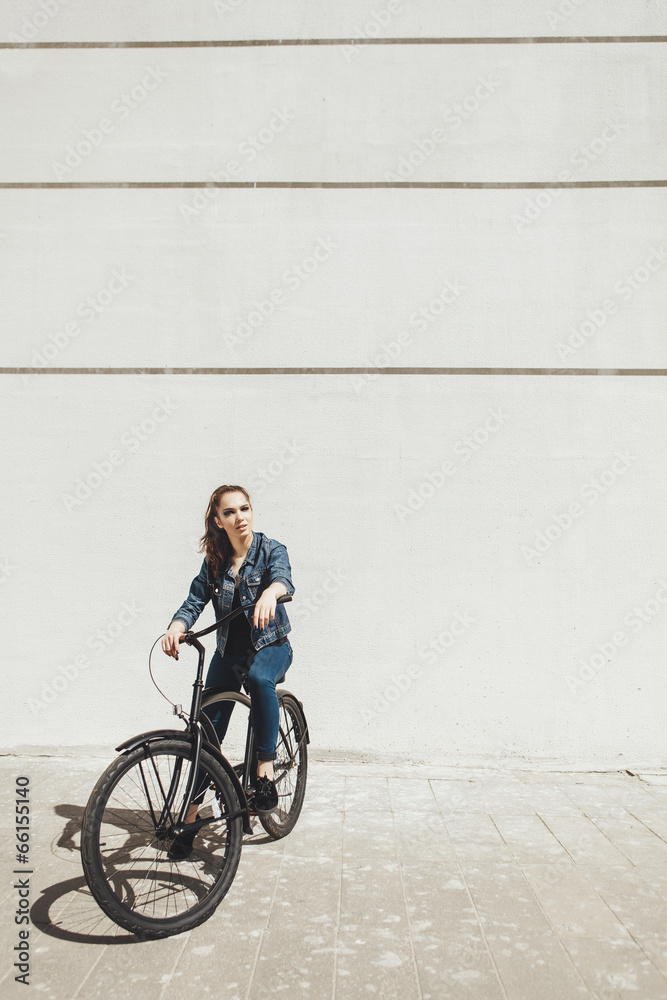 Young woman hipster standing with black bike