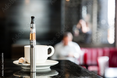 E-cigarette on a bar counter with a cup of coffee