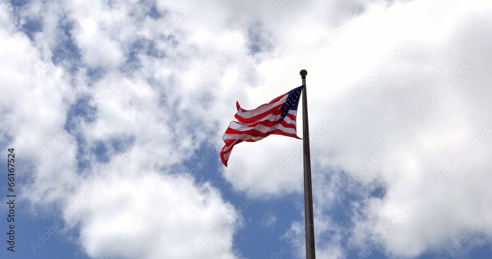 4K American flag - star and stripes floating over a blue sky 