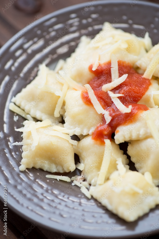 Ravioli with tomato sauce and parmesan, vertical shot, close-up