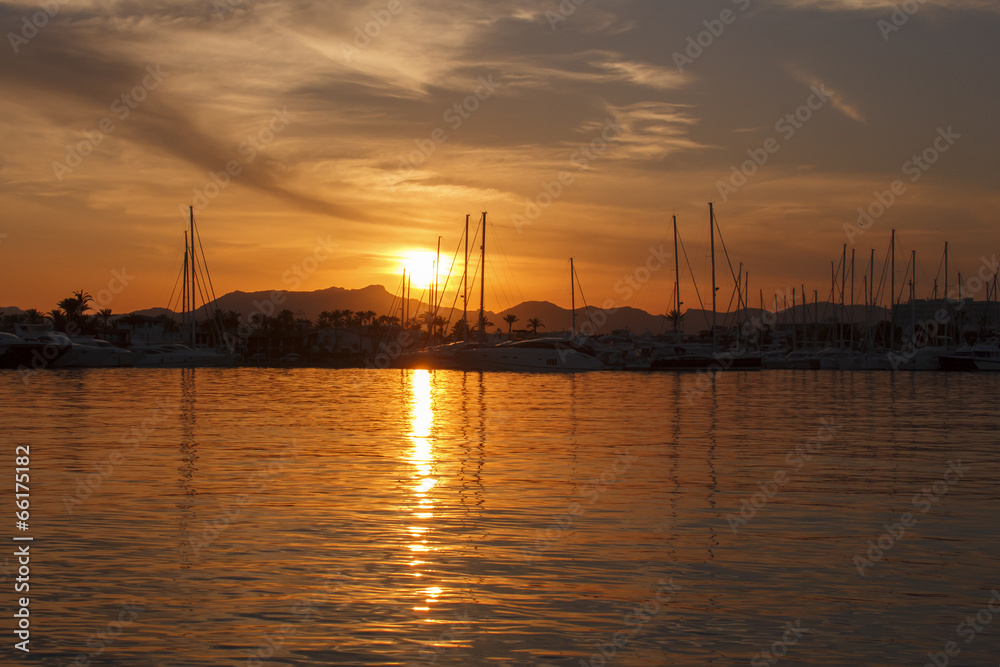 Sunset over harbor with yachts