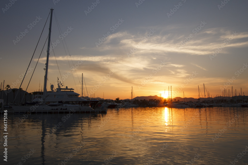 Yachts in harbor at sunset