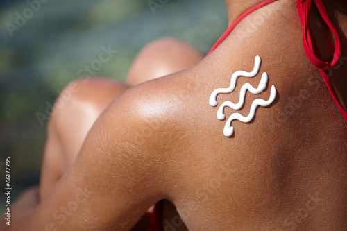 girl back with sunburn and wave of sun lotion