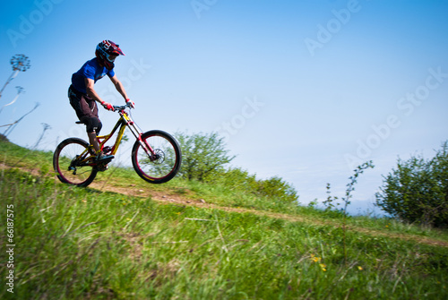 Dounhill cyclist in mountains